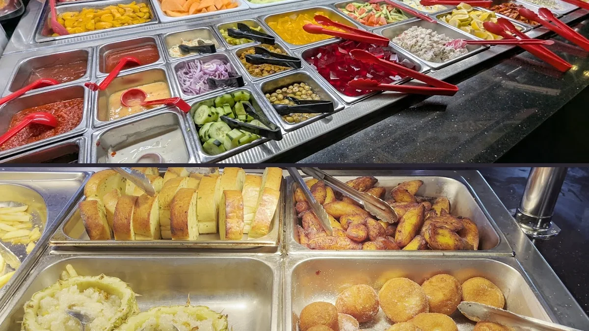 Hibachi grill station beside trays of prepared food.